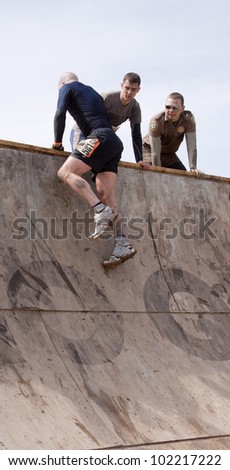 POCONO MANOR, PA - APR 28: A man lifts himself over the steep ramp of the Everest obstacle at Tough Mudder on April 28, 2012 in Pocono Manor, PA. The course is designed by British Special Forces.
