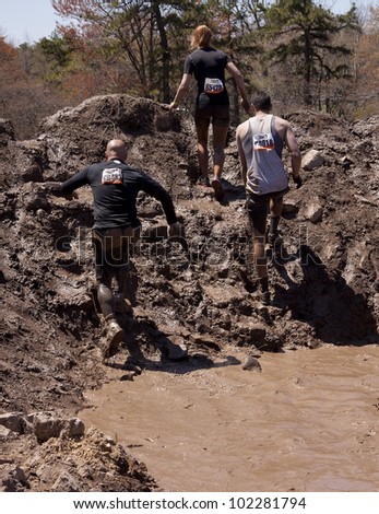 POCONO MANOR, PA - APR 29: Participants walk through several pits of mud and water at Tough Mudder on April 29, 2012 in Pocono Manor, Pennsylvania. The course is designed by British Royal troops.