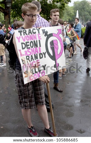 NEW YORK - JUNE 22: A supporter in Washington Square Park holds a sign that lists names of transgendered people who have died on the 8th Annual Trans Day of Action on June 22, 2012 in New York City.