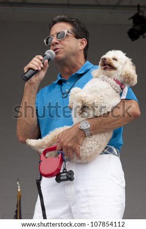 RIDGEFIELD PK, NJ-JULY 14: ABC Channel 7 meteorologist and dog lover, Bill Evans, holding his own dog, speaks to an audience at the 2nd Annual Bark In The Park on July 14, 2012 in Ridgefield Park, NJ.