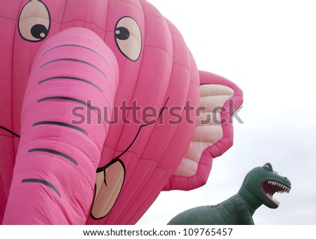 READINGTON, NJ-JUL 29: A close up of the Nelly B Pink Elephant and T-Rex balloons tethered to the ground at the Quick Chek New Jersey Festival of Ballooning on July 29, 2012 in Readington, NJ.