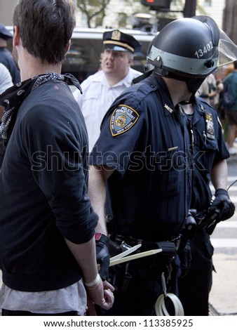 NEW YORK - SEPT 17: A policeman holds the on to a suspect after arresting the unidentified man on the 1yr anniversary of the Occupy Wall St protests on September 17, 2012 in New York City, NY.