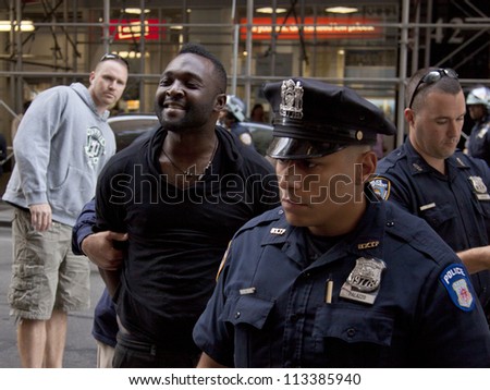 NEW YORK - SEPT 17: An unidentified man smiles as he is arrested on the 1yr anniversary of the Occupy Wall St protests on September 17, 2012 in New York City, NY. Attempts to elude police were futile.