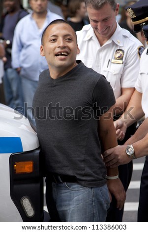 NEW YORK - SEPT 17: Police handcuff an unidentified man as he is arrested outside of Zuccotti Park on the 1yr anniversary of the Occupy Wall St protests on September 17, 2012 in New York City, NY.
