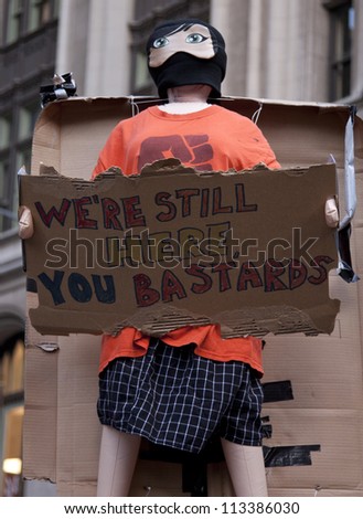 NEW YORK - SEPT 17: A sign that reads 'We're Still Here' held by a protester in Zuccotti Park during on the 1yr anniversary of the Occupy Wall St protests on September 17, 2012 in New York City, NY.