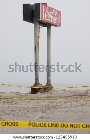 SEASIDE HEIGHTS, NJ - JAN 13: Police tape strung near the boardwalk Coca Cola sign in the fog on January 13, 2013 in Seaside Heights, NJ. Clean up continues 75 days after Hurricane Sandy hit in 2012.