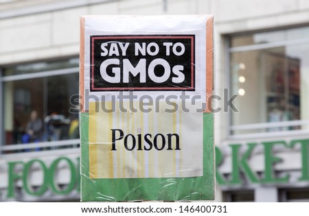 NEW YORK-MAY 25: A sign that says \'Say No To GMOs Poison\' held by a protestor during the global March Against Monsanto as they pass in front of Whole Foods grocery store on May 25, 2013 in Manhattan.