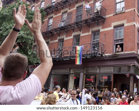 NEW YORK-JUN 30: People on Christopher Street cheer and wave rainbow flags in celebration during in the 44th Annual NYC Pride March on June 30, 2013 in Manhattan.
