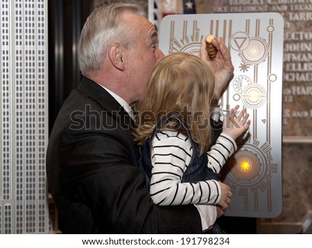NEW YORK-APR 21, 2014: Police Commissioner William Bratton gets help from the daughter of an honored NYPD officer to light the Empire State Building in blue and purple for Police Memorial Week.