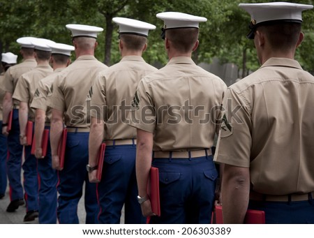 NEW YORK - MAY 23, 2014: A group of U.S. Marines exit in a single file line after taking part in the re-enlistment and promotion ceremony at the National September 11 Memorial site.