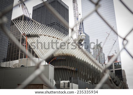 NEW YORK - SEPT 11, 2014: The white spokes of the new Transit Hub still under construction at the World Trade Center site in Lower Manhattan, as seen through the metal safety fence.