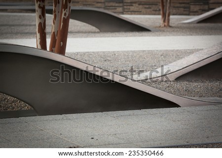 ARLINGTON, VA - SEPT 13, 2014: Granite and stainless steel memorial units and Crape Myrtle trees at the Pentagon Memorial. Each bench has a pool of water and name of each victim of the 2001 attack.