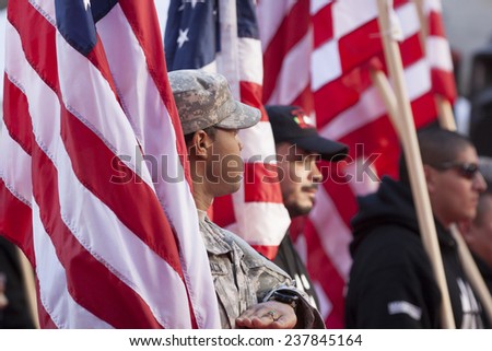NEW YORK - NOV 11, 2014: US vets carry American Flags as they march in the 2014 America\'s Parade held on Veterans Day in New York City on November 11, 2014.