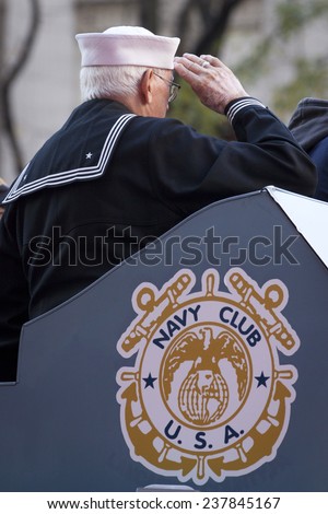 NEW YORK - NOV 11, 2014: A older vet from the US Navy salutes from the Navy Club float as it passes the VIP stage during the 2014 Americas Parade on Veterans Day in New York City on November 11, 2014.