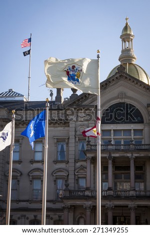 TRENTON, NJ - APRIL 4, 2015: The NJ State Flag flying in front of the New Jersey State House located in Trenton. The capitol building for the state of New Jersey is located on State St.