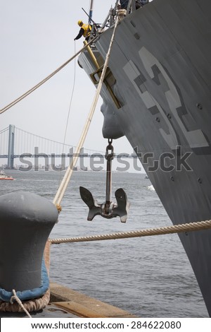 STATEN ISLAND, NY - MAY 20 2015: Linesmen work on the bow of USS Barry (DDG 52) guided-missile destroyer mooring for Fleet Week NY at Sullivans Pier with the Verrazano-Narrows Bridge in background.