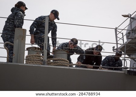 STATEN ISLAND, NY - MAY 20 2015: Linesmen work on the USS Barry (DDG 52) guided-missile destroyer while mooring for Fleet Week NY at Sullivans Pier.