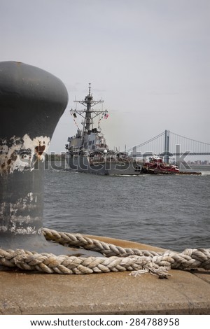 STATEN ISLAND, NY - MAY 20, 2015: USS Barry (DDG 52) is guided into port by McAllister tugboats at Sullivans Pier in Staten Island after the Parade of Ships that starts Fleet Week.