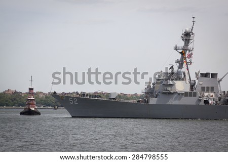 STATEN ISLAND, NY - MAY 20, 2015: USS Barry (DDG 52) and McAllister tugboat before the warship is guided into port at Sullivans Pier in Staten Island after the Parade of Ships that starts Fleet Week.