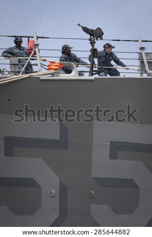 STATEN ISLAND, NY - MAY 20 2015: Low angle view of linesmen work from the bow of the USS Stout (DDG 55) guided-missile destroyer while mooring for Fleet Week NY 2015 at Sullivans Pier