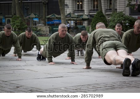 NEW YORK - MAY 21 2015: A group of US Marines doing push ups during an early morning boot camp exercise in Bryant Park at Marine Day during Fleet Week NY 2015.