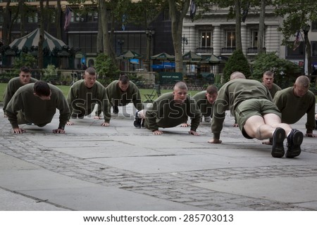 NEW YORK - MAY 21 2015: A group of US Marines doing push ups during an early morning boot camp exercise in Bryant Park at Marine Day during Fleet Week NY 2015.