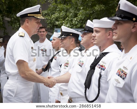 NEW YORK - MAY 22 2015: Admiral Phil Davidson shakes the hand of a U.S. Navy sailor who took part in the re-enlistment and promotion ceremony at the National September 11 Memorial site.