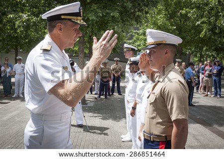 NEW YORK - MAY 22 2015: A US Marine renders a salute to Admiral Phil Davidson, Commander, US Fleet Forces Command, during the promotion ceremony at the National September 11 Memorial site.