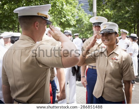 NEW YORK - MAY 22 2015: A US Marine Corpsman receives a salute from a fellow Marine after the promotion ceremony at the National September 11 Memorial site during Fleet Week 2015.