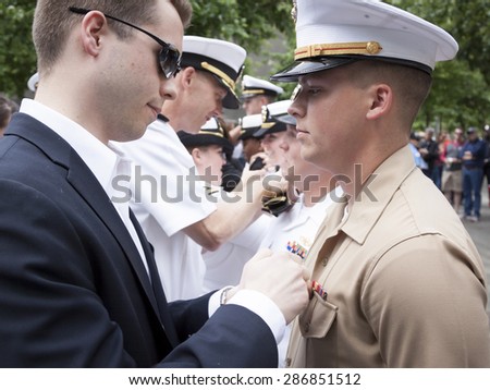 NEW YORK - MAY 22 2015: A US Marine receives his promotion insignia during the ceremony held at the National September 11 Memorial site during Fleet Week 2015.