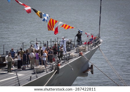 STATEN ISLAND, NY - MAY 24 2015: A US Navy sailor speaks to citizens during a public tour on the bow of guided-missile destroyer USS Stout (DDG 55) moored at Sullivans Pier during Fleet Week NY 2015.