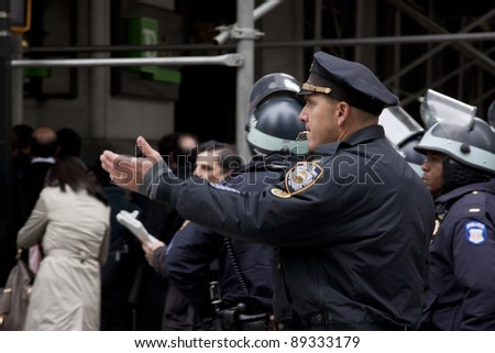 NEW YORK - NOV 17:  A police officer directs traffic on Broadway at Wall St near the entrance to the New York Stock Exchange on the \'Day of Disruption\' on November 17, 2011 in New York City, NY.