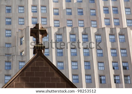 The tops of spires of Trinity Church with modern buildings behind in New York City.