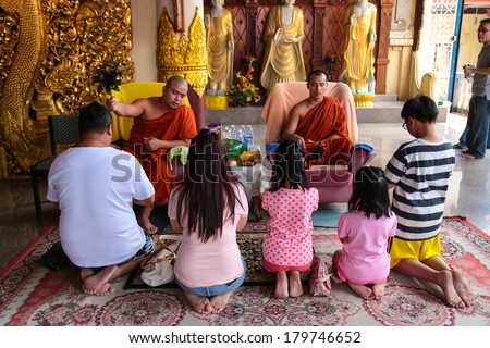 PENANG, MALAYSIA- FEB 2, 2014 : Buddhist monk blessing a family that offer their prayer inside the Dhammikarama, a burmese buddhist temple in Penang Malaysia during Chinese New Year 2014.