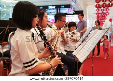 KUALA LUMPUR, MALAYSIA - JAN 25, 2015 : School boys and girls playing musical instrument during chinese new year at Paviollion shopping mall, Kuala Lumpur Malaysia.