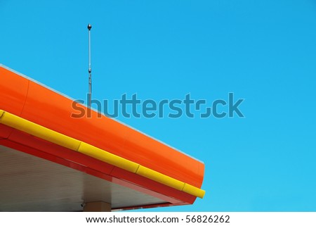 Lightning rod on orange color roof top with clear blue sky.