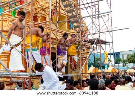 SERDANG, MALAYSIA - 10 SEPT:  Indian devotees climbing the scaffolding at the Sri Maha Kaliamman temple opening ceremony at Serdang, Malaysia on 10 September, 2010.