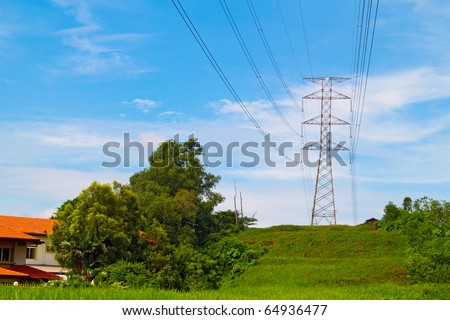 Power cable tower on a hill near housing area. Concept of power transmission.