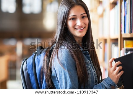 A portrait of an Hispanic college student in the library