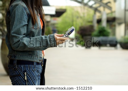 A woman with a cellphone in an outdoor shopping mall