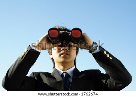 Businessman looking through binoculars, can be used for vision/prospects metaphor