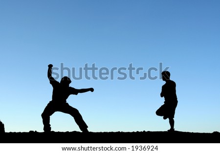 Two men practicing martial arts, in silhouette