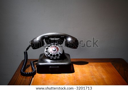An old black telephone on an old table