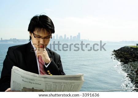 A businessman reading a financial newspaper outdoor