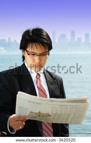A businessman reading a financial newspaper outdoor
