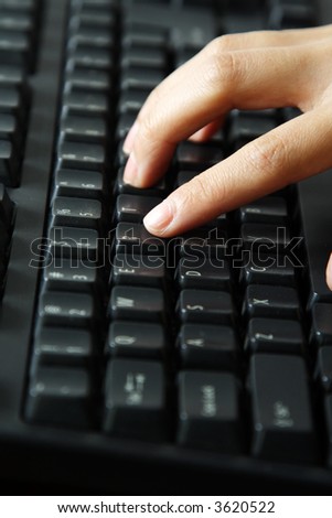 A businesswoman typing on a black keyboard