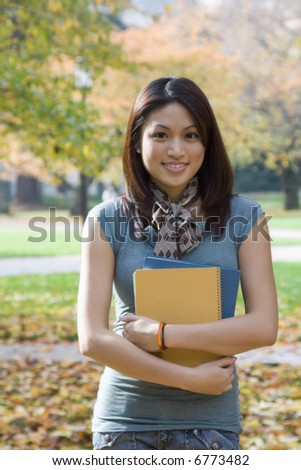 A beautiful college student carrying books at the campus