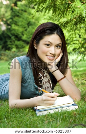 A beautiful college student studying outdoor in the park