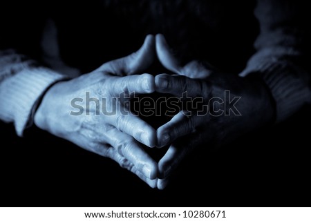 A closeup shot of senior clasped hands in blue tone