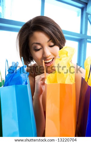 A shot of a beautiful black woman looking at her shopping bags in a store